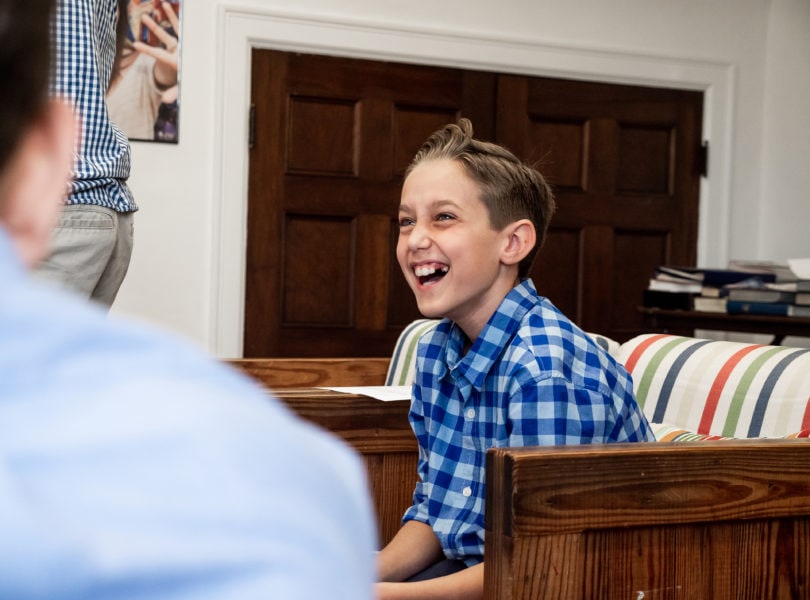 A boy laughs during middle school youth group