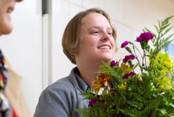 A woman delivers flowers to a nursing home.