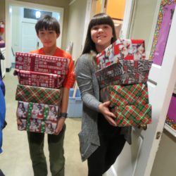 Two youth carry wrapped Christmas gifts for Baltimore Seafarers