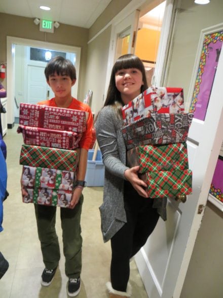 Two youth carry wrapped Christmas gifts for Baltimore Seafarers