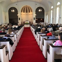 A view of people in worship from the back of the sanctuary