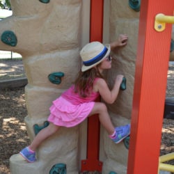 In pink, little girl climbs.