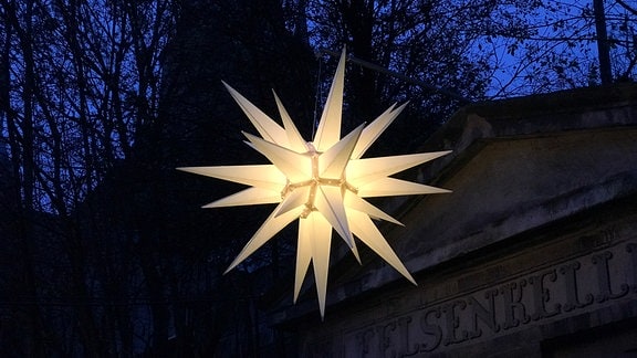 A Moravian star hangs against a dark sky