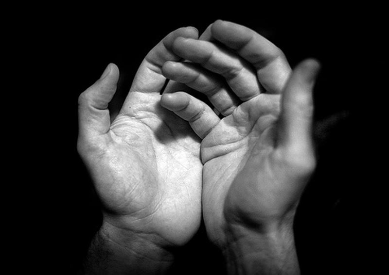 a black and white photo of open hands