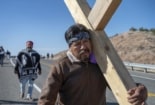 Pilgrims carrying cross on the road to Chimayo