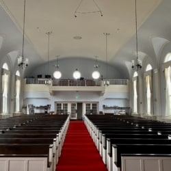 Pews separated by center aisle and red carpeting