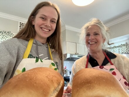 Youth holds fresh bread with mentor