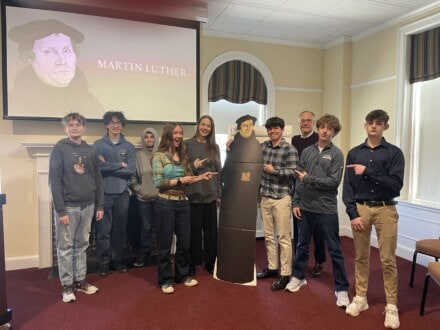 Youths standing with cardboard cutout of Martin Luther